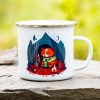 White enamel camping mug featuring an illustration of an orange cat sitting in front of a tent, sipping a hot drink by a small campfire, surrounded by trees and a night sky.