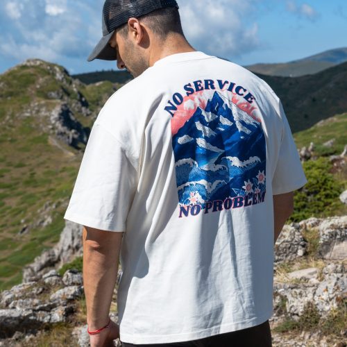Man wearing oversized organic cotton T-shirt with mountain and sea print "No Service No Problem"
