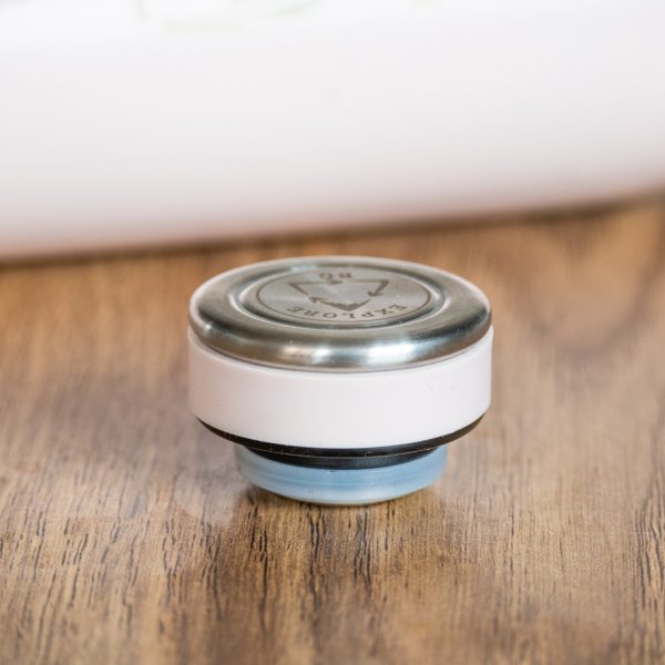 Close-up of pink thermos cap with metal top and silicone seal.