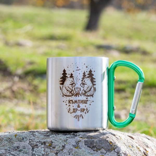 metalno-kenche-za-planina Stainless steel camping mug with laser-engraved bear design and green carabiner handle.