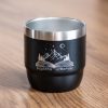 Black mini insulated coffee cup with laser-engraved mountain and book design.