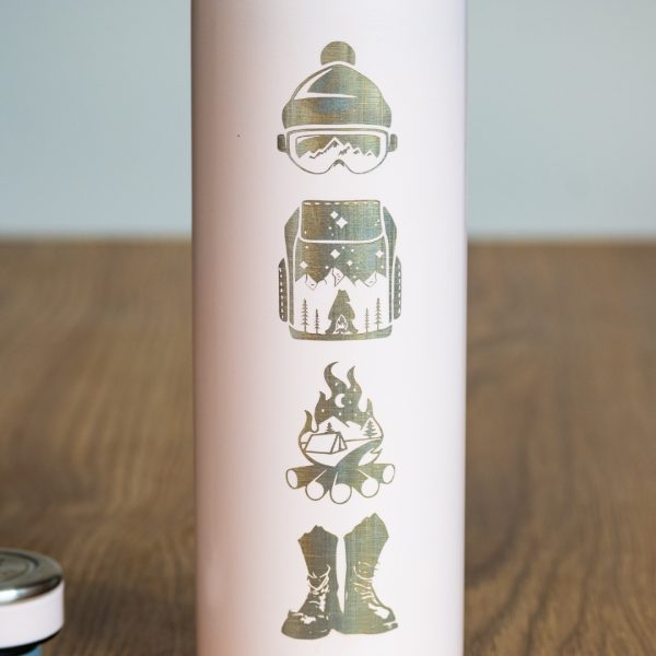 Close-up of laser-engraved winter sports icons on a pink thermos.