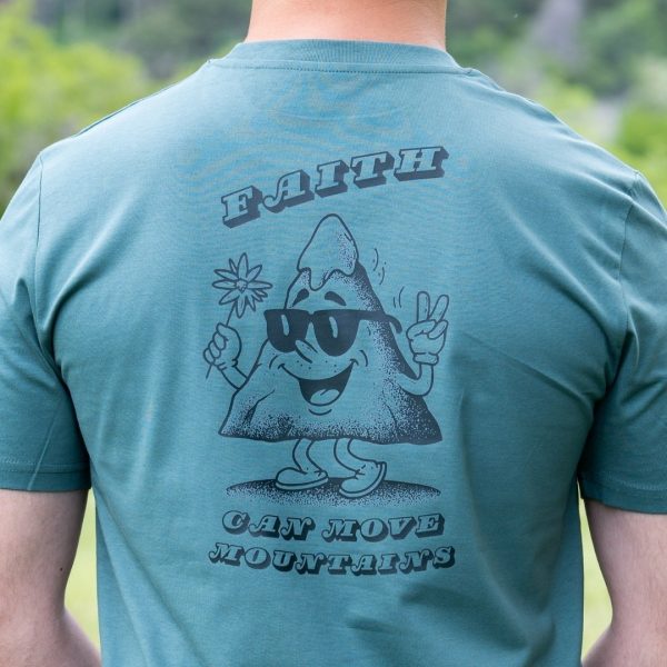 Close-up of green organic cotton t-shirt with Faith Can Move Mountains mountain graphic on back