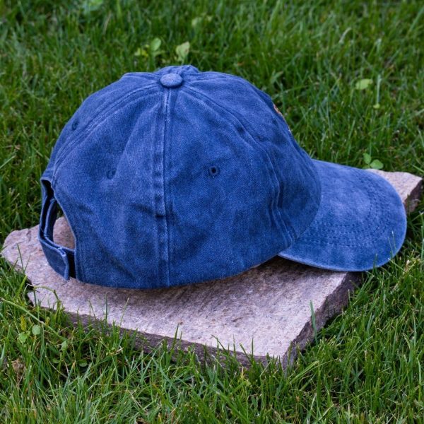 Back view of navy blue vintage cotton baseball cap with adjustable Velcro strap, washed finish and curved visor