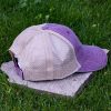 Side view of purple trucker cap made from organic and recycled cotton with soft mesh back and adjustable closure