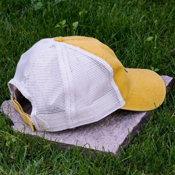 Back view of yellow trucker cap made from organic and recycled cotton with soft mesh back and adjustable closure