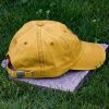 Back view of yellow vintage organic cotton baseball cap with adjustable metal buckle, washed finish and curved visor