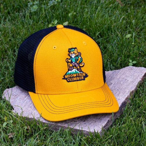 Front view of yellow trucker cap made from 100% recycled micro twill with black mesh back and embroidered hiking cat