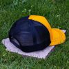 Untitled design (76) Rear side view of yellow trucker cap made from 100% recycled micro twill with black breathable mesh back and adjustable snapback closure
