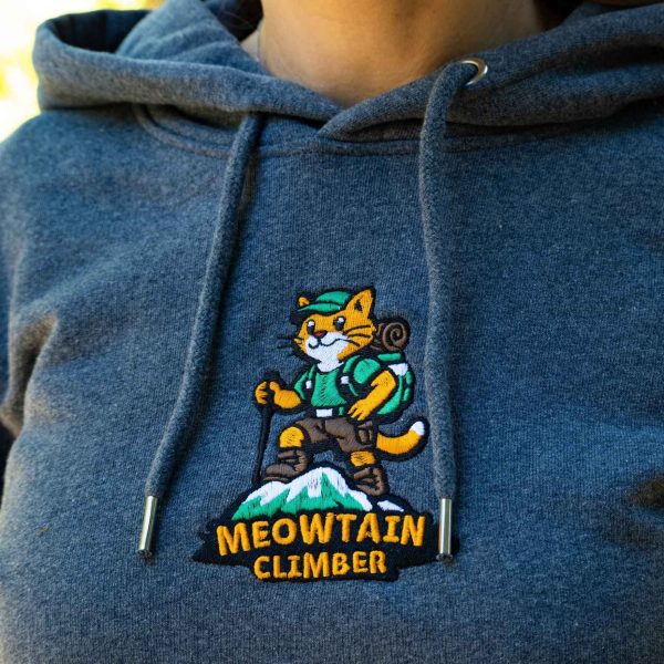 broderia-meowtain-climber-varhu-tumnosiv-suitshart-s-kachulka Close-up of embroidered “Meowtain Climber” cat mountaineer design on a dark grey hoodie