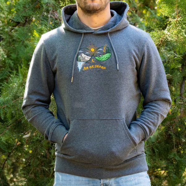 tumnosiv-uniseks-suitshart-s-kachulka-i-broderia-do-bezkraya Man and woman wearing dark grey unisex hoodies with embroidered mountain landscape and “До безкрая” design outdoors